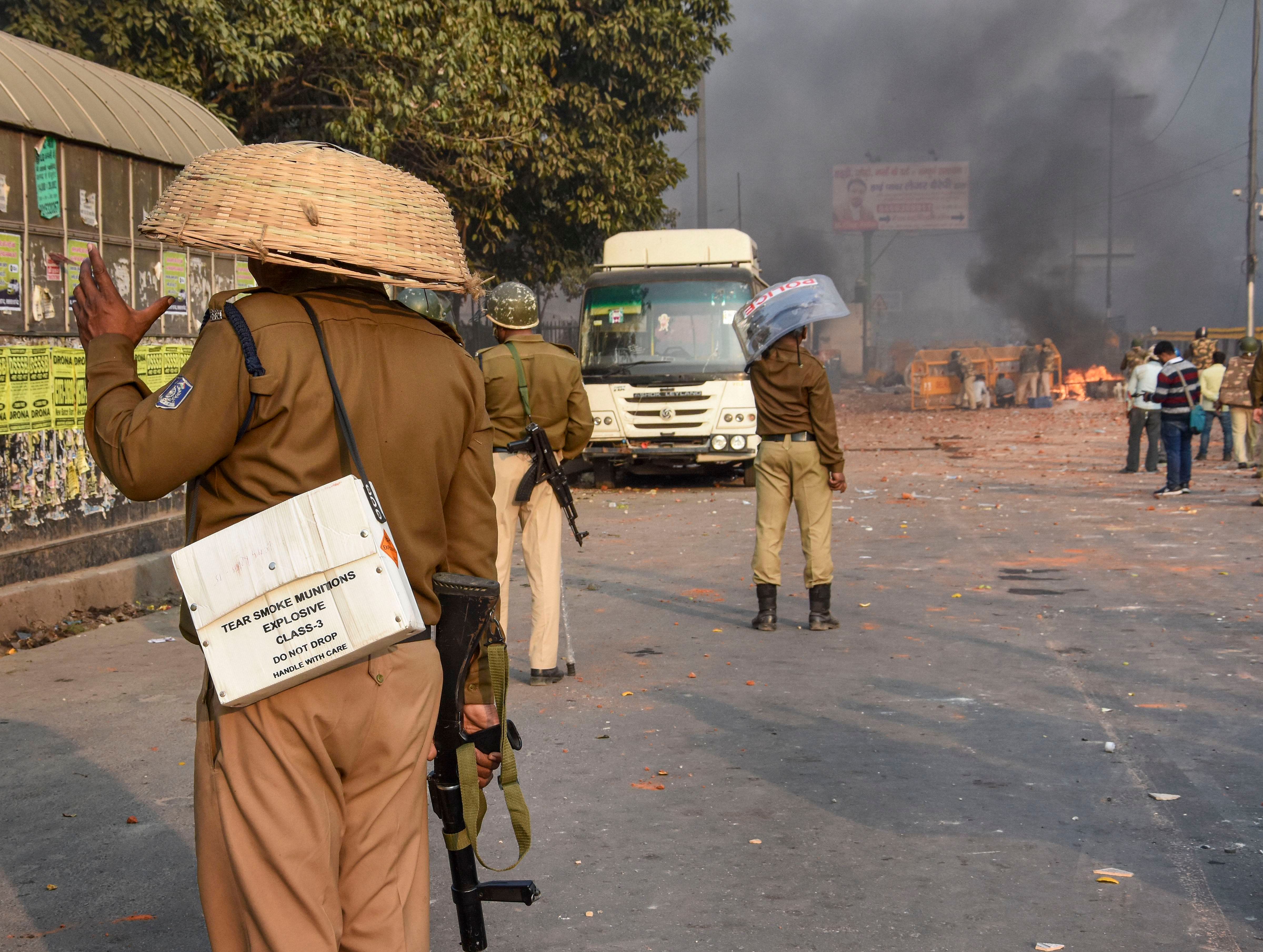 A police personnel uses a bamboo basket as protection against brick-bats during clashes between a group of anti-CAA protestors and supporters of the new citizenship act, at Chand Bagh in Bhajanpura, in north-east Delhi, Monday, Feb. 24, 2020. (PTI Photo)