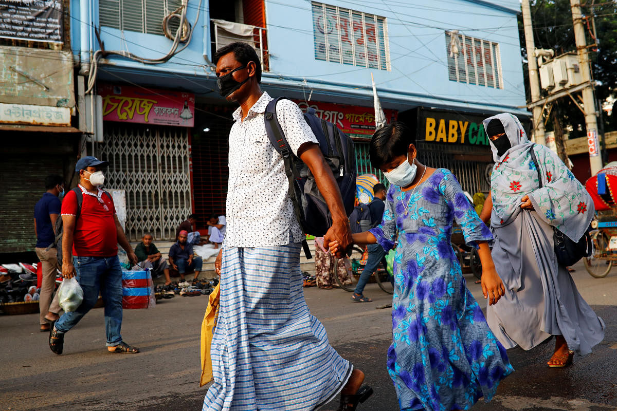 People wear protective masks as they walk on the street amid concerns over coronavirus disease (COVID-19) in Dhaka, Bangladesh, June 25, 2020.  Credit/Reuters Photo