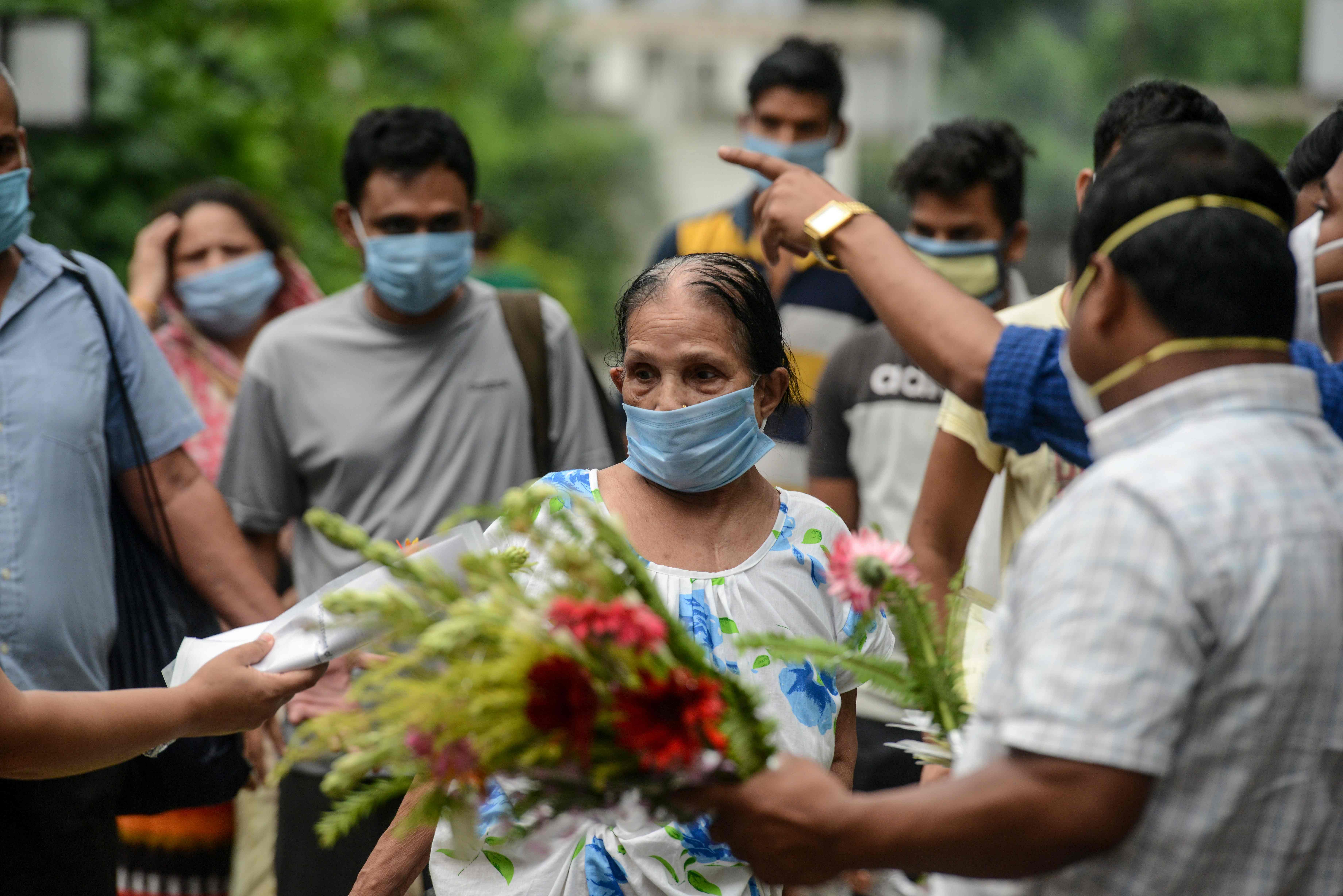 Medical staff hands over certificates and flowers to a patient (C) recovered from the COVID-19 coronavirus after their discharge on the occasion of the Indian National Doctors' Day at a hospital in Siliguri on July 1, 2020. (Photo by AFP)