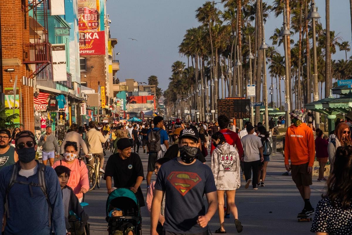  In this file photo taken on May 23, 2020 people walk at the boardwalk in Venice Beach during the first day of the Memorial Day holiday weekend amid the novel Coronavirus, COVID-19, pandemic in California. Credit/AFP Photo