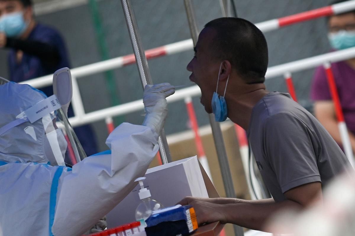 A man receives a swab test during widespread testing for the COVID-19 coronavirus outbreak in Beijing on July 1, 2020. Credit/AFP Photo