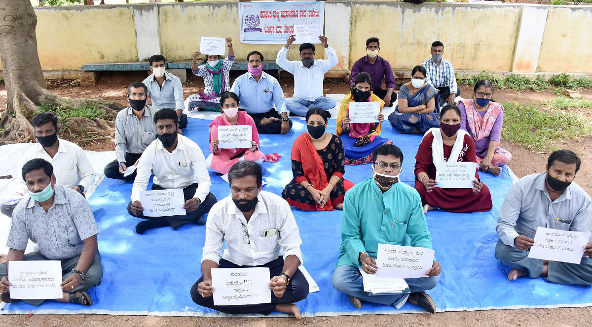 Members of Karnataka State Association of Teaching and Non-Teaching Staff of Unaided Schools and Colleges stage a protest in Mysuru, on Tuesday.