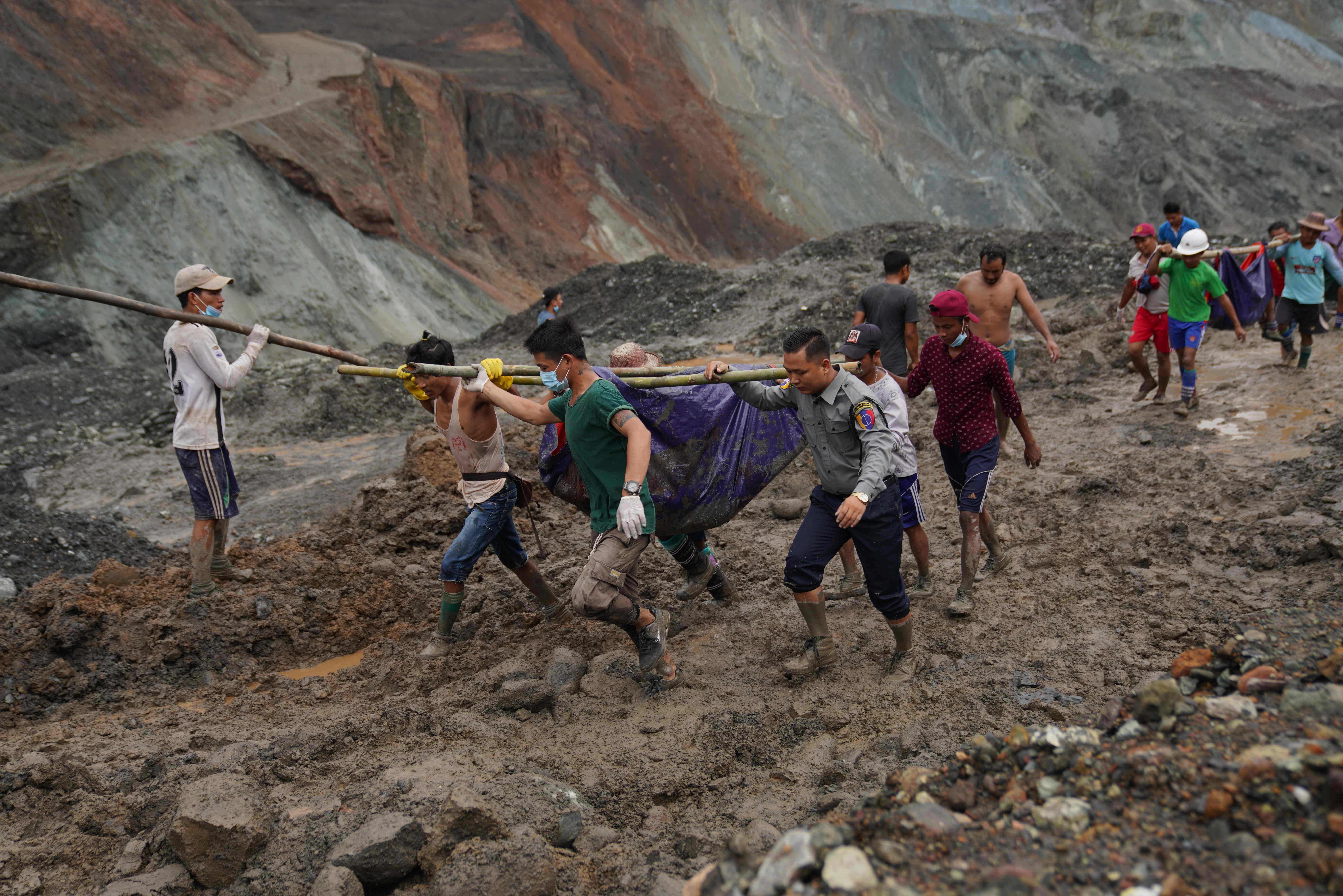 Rescuers recover bodies near the landslide area in the jade mining site in Hpakhant in Kachin state on July 2, 2020. - The battered bodies of more than 120 jade miners were pulled from a sea of mud after a landslide in northern Myanmar on July 2 after one of the worst-ever accidents to hit the treacherous industry. (Photo by AFP)