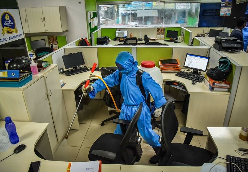  A municipal corporation worker sprays disinfectant inside a bank as a preventive measure to contain the spread of coronavirus. Credits: PTI Photo