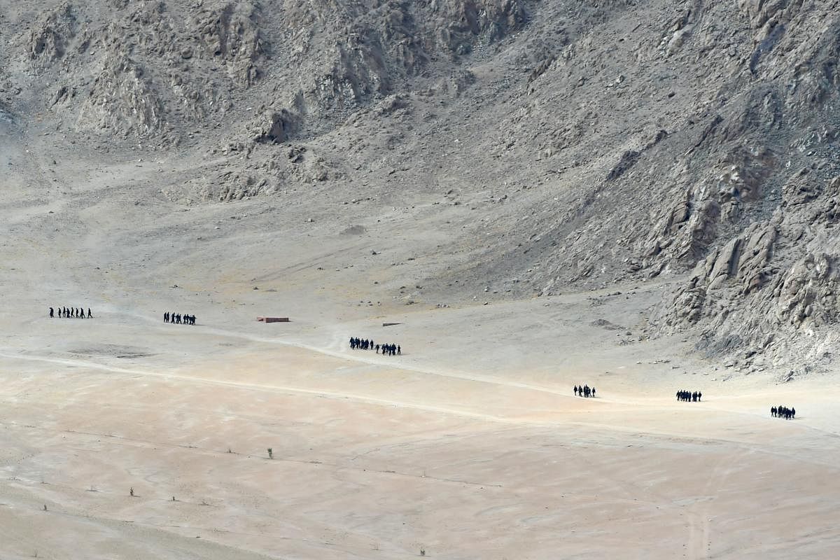 Indian soldiers walk at the foothills of a mountain range near Leh, the joint capital of the union territory of Ladakh, on June 25, 2020. - Indian fighter jets roared over a flashpoint Himalayan region on June 24 as part of a show of strength following wh