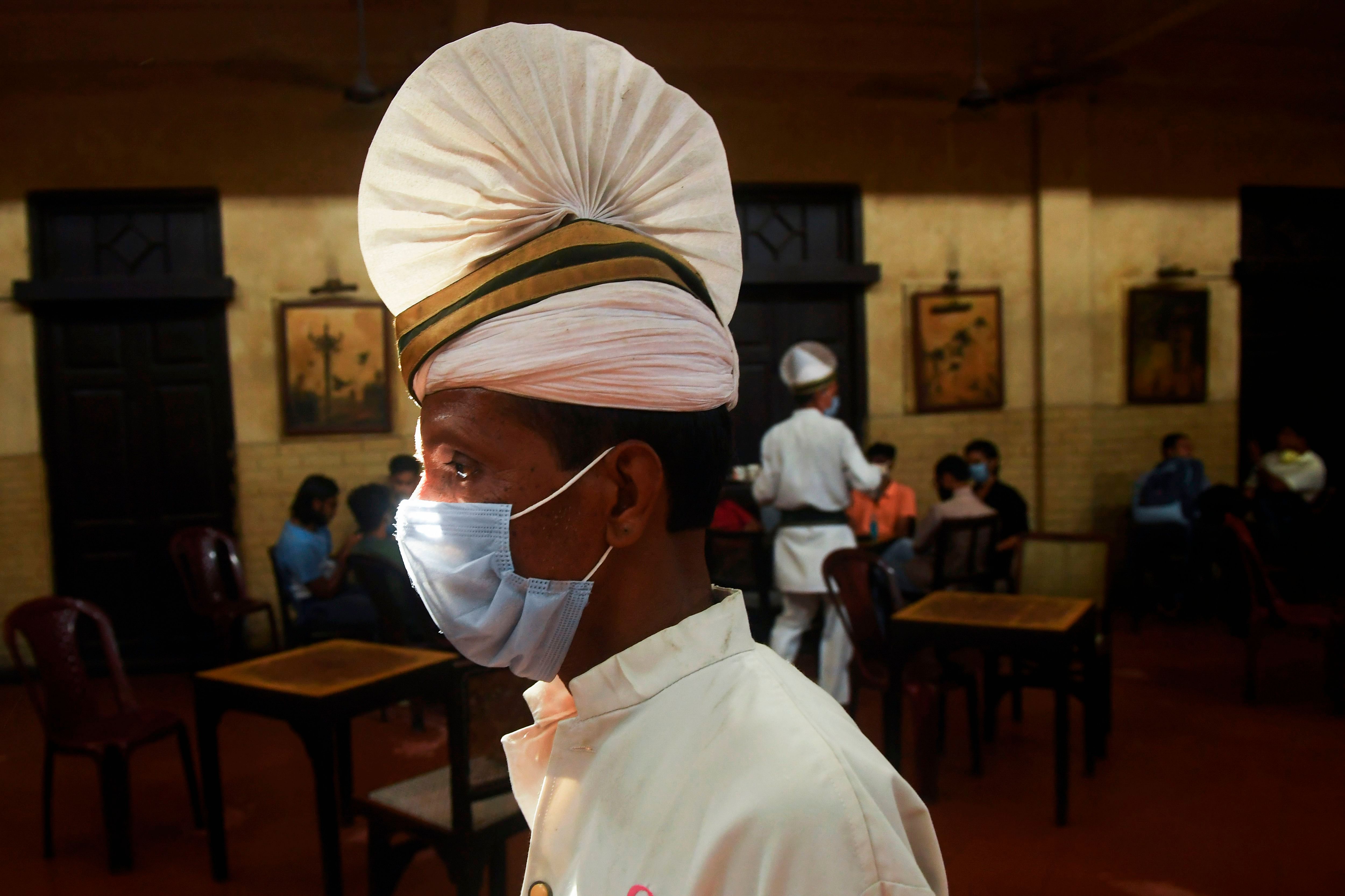 A waiter wearing a facemask works at the Indian Coffee House after the establishment reopened in Kolkata. Credit: AFP