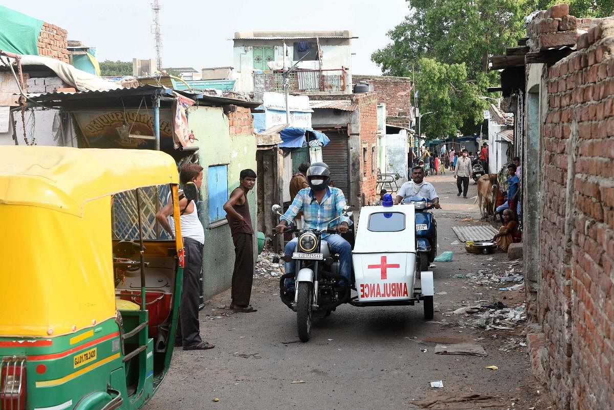 A man drives his two-wheeler sidecar converted in an ambulance in a slum area amid coronavirus crisis (AFP Photo)
