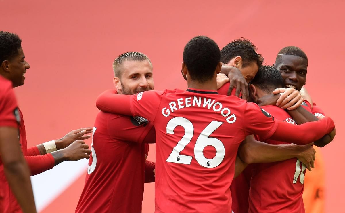 Manchester United's Portuguese midfielder Bruno Fernandes is congratulated by teammates after scoring a goal during the English Premier League football match between Manchester United and Bournemouth at Old Trafford. Credit: AFP
