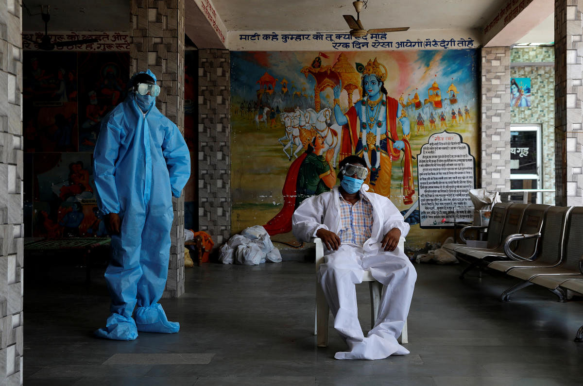 A priest and a labourer wear personal protective equipment (PPE) at a crematorium, amid the spread of the coronavirus disease (Covid-19), in New Delhi, India, July 3, 2020. Credit/Reuters Photo