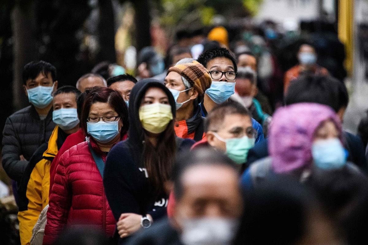 People wearing facemasks as a preventative measure following a coronavirus outbreak which began in the Chinese city of Wuhan, line up to purchase face masks from a makeshift stall after queueing for hours following a registration process during which they were given a pre-sales ticket, in Hong Kong on February 5, 2020. Credit/AFP Photo