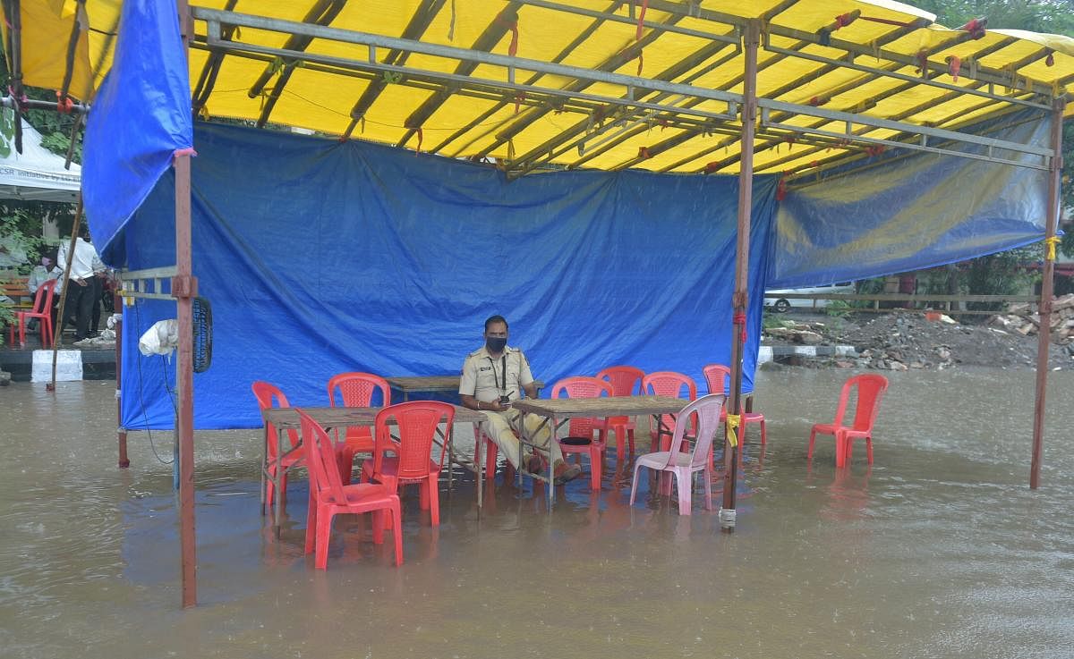 A police constable sits at a waterlogged check post during heavy rain, in Mumbai. PTI