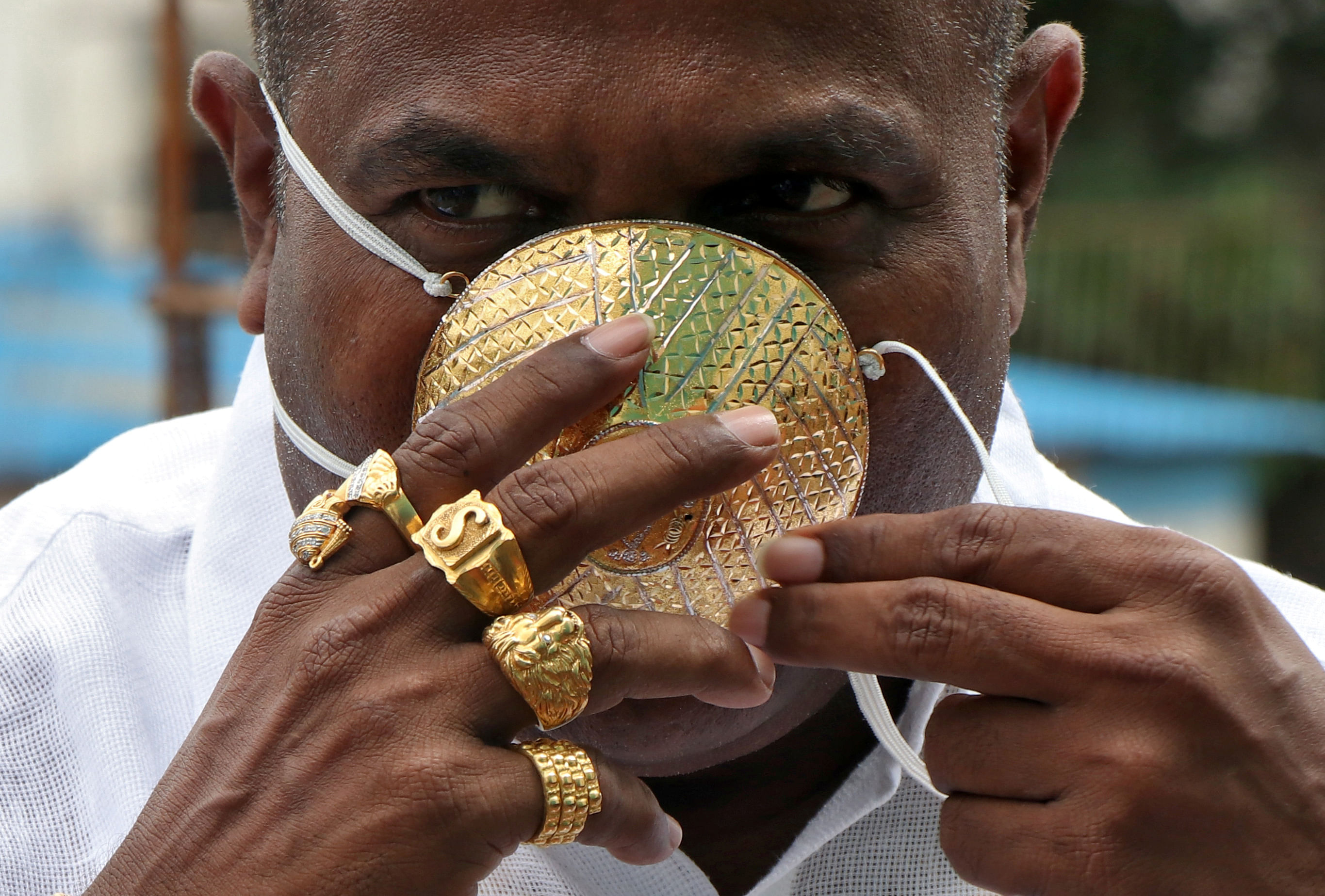Shankar Kurhade (48), shows his face mask made out of gold as he poses for a photograph amidst the spread of the coronavirus disease (COVID-19) in Pune, India, July 4, 2020. Kurhade claims the mask weighs 50 grams. Credit: Reuters