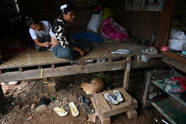 Pan Ei Phyu (L) treating her husband Sai Ko (R), who survived a deadly landslide in an area of open-cast jade mines, near Hpakant. Credit: AFP