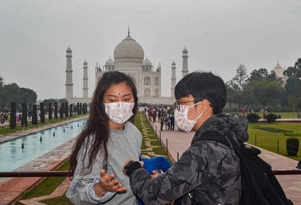 Tourists wearing protective face masks outside the Taj Mahal, in Agra. Credit: PTI Photo