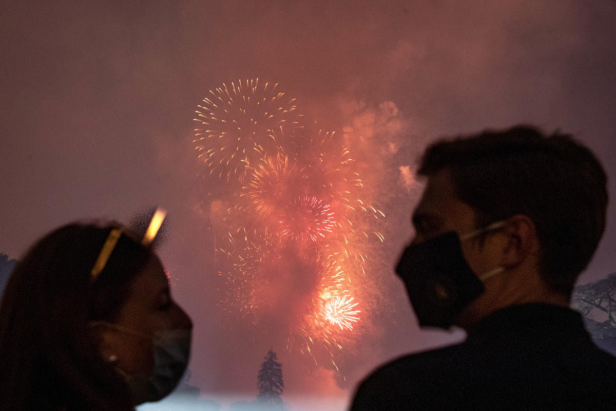 White House guests wearing protective face masks due to the coronavirus disease (COVID-19) pandemic watch the Washington, D.C. fireworks display from the South Lawn. Credit: Reuters