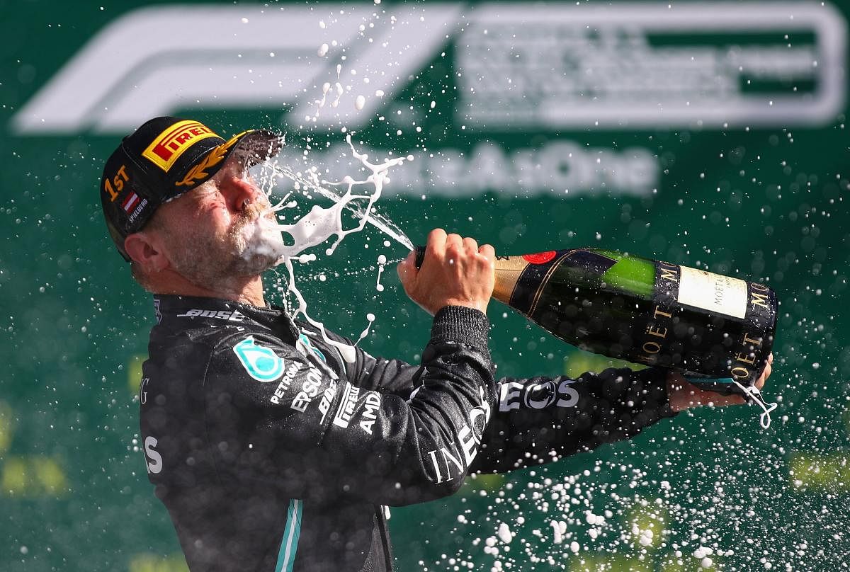 Mercedes' Finnish driver Valtteri Bottas celebrates with champagne on the podium after the Austrian Formula One Grand Prix race on July 5, 2020 in Spielberg, Austria. Photo credit: AFP