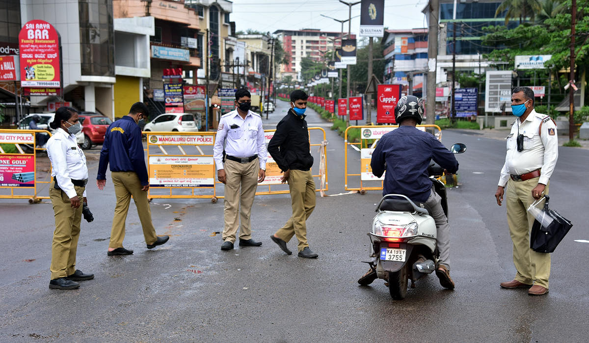Police personnel check the movement of vehicles at Pumpwell, following complete lockdown announced by the government.