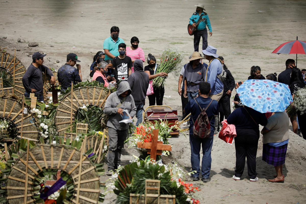 Cemetery workers and relatives are seen next to the coffin of a woman, who died of the coronavirus disease (COVID-19), during her funeral at the Xico cemetery, as the coronavirus disease (COVID-19) outbreak continues, in Valle de Chalco, in the State of Mexico, Mexico, June 27, 2020. Credit/Reuters Photo