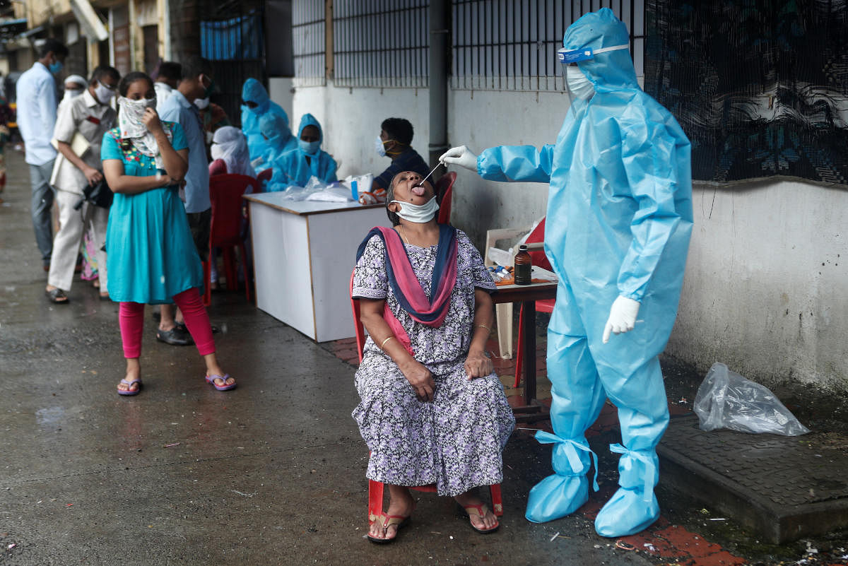 A healthcare worker collects a swab sample from a woman during a medical campaign for the coronavirus disease (Covid-19), in Mumbai, India, July 4, 2020. Credit: Reuters Photo