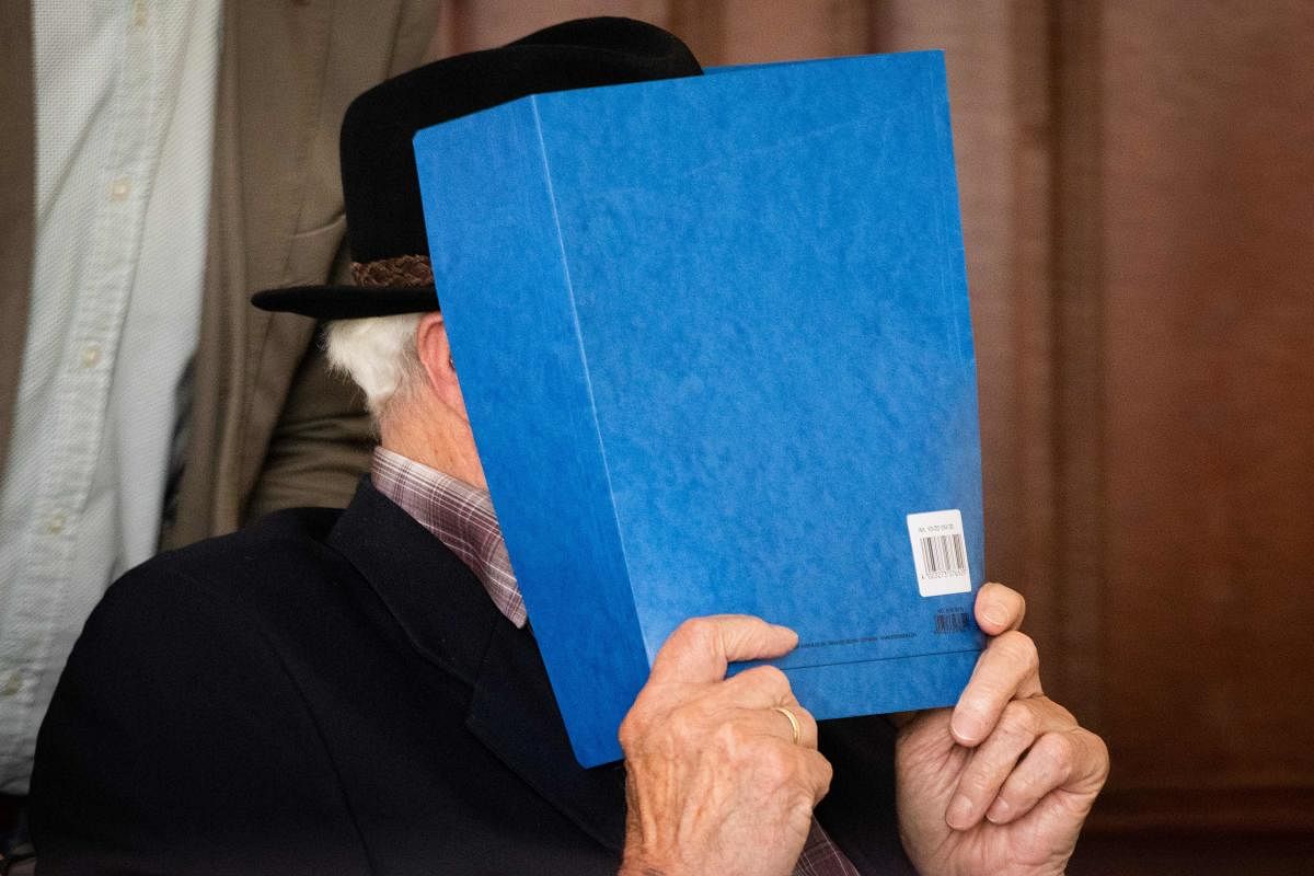 Bruno Dey, a former SS-watchman at the Stutthof concentration camp, hides his face behind a folder before a hearing in his trial on July 6, 2020 in Hamburg, northern Germany. Credit: AFP Photo