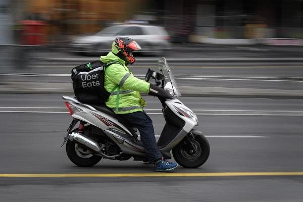An Uber Eats deliverer rides his scooter in a street in Lausanne, amid the COVID-19 outbreak, caused by the novel coronavirus. Credits: AFP Photo