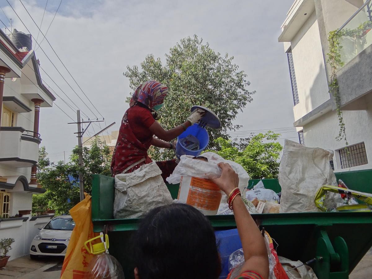 Gangamma sorts through garbage on her route. DH Photo/Varsha Gowda