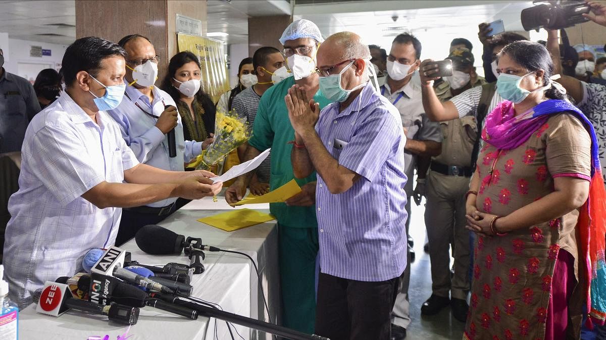 Delhi Chief Minister Arvind Kejriwal presents a certificate to the 1000th COVID-19 recovered patient during his rousing send-off from the Rajiv Gandhi Super Specialty Hospital, in New Delhi, Monday July 6, 2020. Credit: PTI Photo