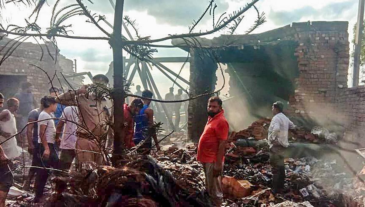 Police personnel inspect the candle-manufacturing factory after a major fire broke out in it, at Modi Nagar in Ghaziabad. Credit: PTI