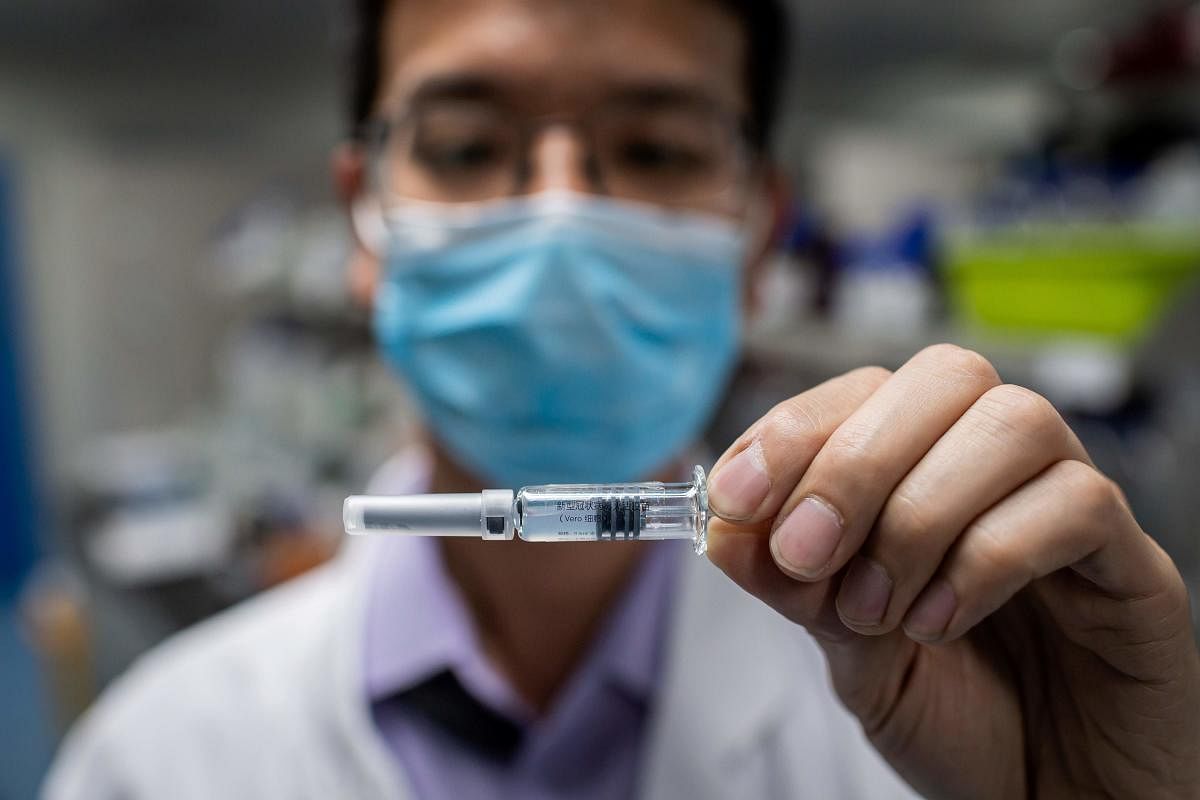This file photo taken on April 29, 2020 shows an engineer displaying an experimental vaccine for the coronavirus that was tested at the Quality Control Laboratory at the Sinovac Biotech facilities in Beijing. Credit: AFP/File