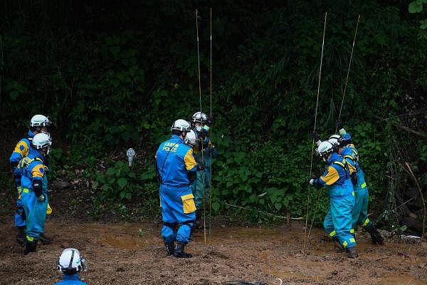 Rescue workers search for missing people at a landslide site caused by heavy rain in Tsunagi, Kumamoto prefecture. Credit: AFP