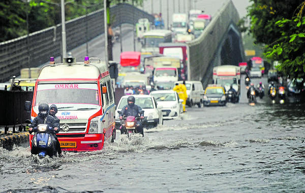 Vehicles move through a waterlogged street in Mumbai. Credit: PTI