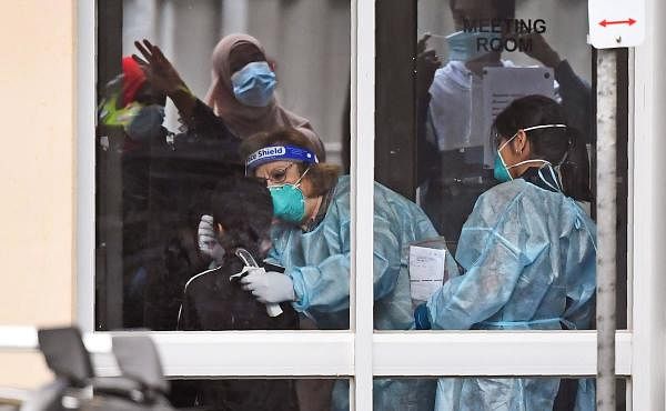 Medical staff perform a COVID-19 coronavirus test on a resident of one of nine public housing estates locked down due a spike in infection numbers in Melbourne on July 6, 2020. Credits: AFP Photo