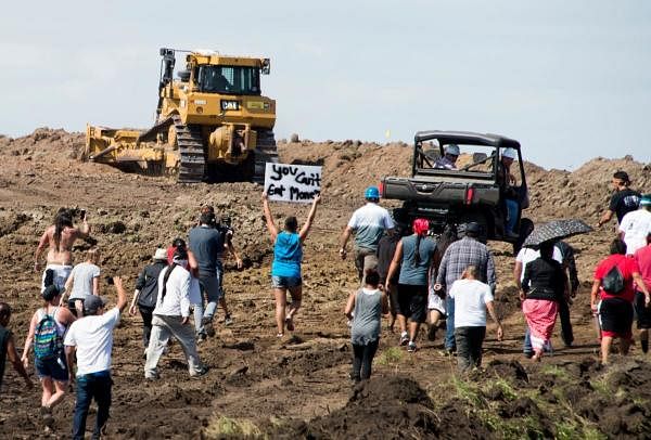 Native American protestors and their supporters are confronted by security during a demonstration against work being done for the Dakota Access Pipeline (DAPL) oil pipeline, near Cannon Ball, North Dakota. Credits: AFP Photo