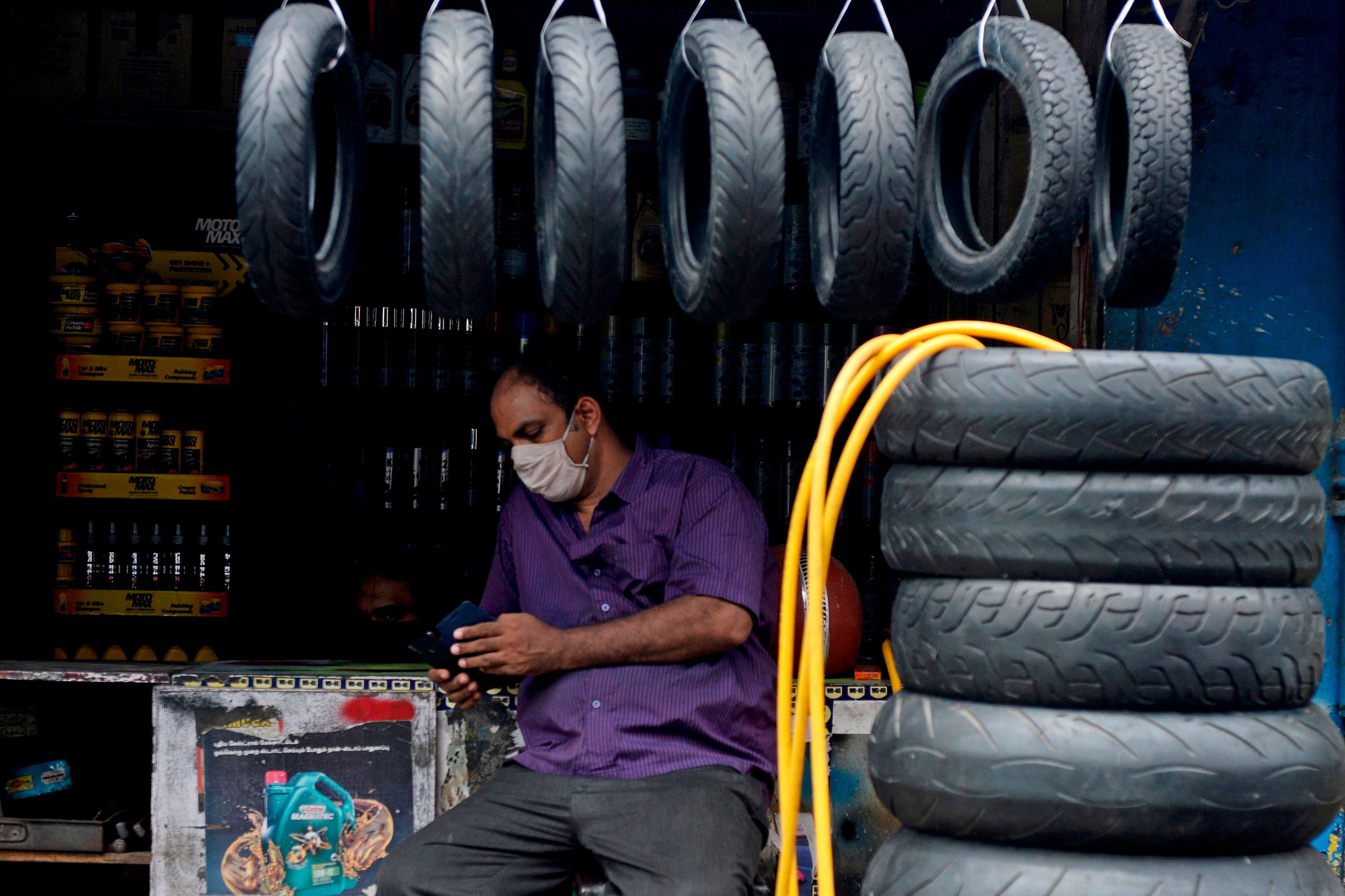 A shopkeeper waits for customers at a second hand automobile spare market in Chennai. Credit: AFP Photo