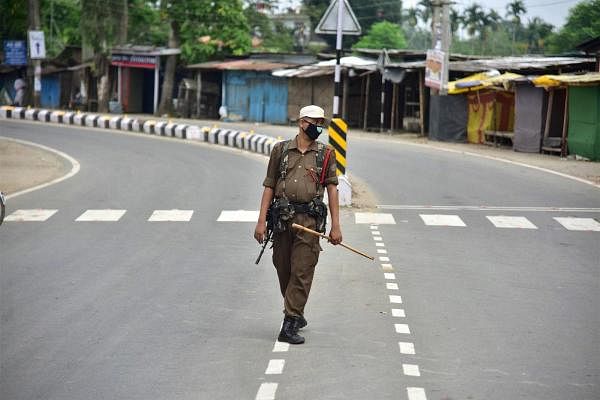 A security personnel stands guard during the strict lockdown imposed by the Assam Government to curb the spread of the novel coronavirus, in Nagaon District, Saturday, July 4, 2020. Credit: PTI Photo