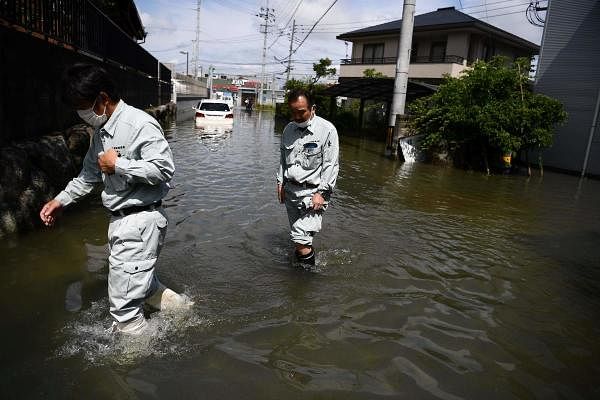 People wade through flood waters in Japan. Credit: AFP