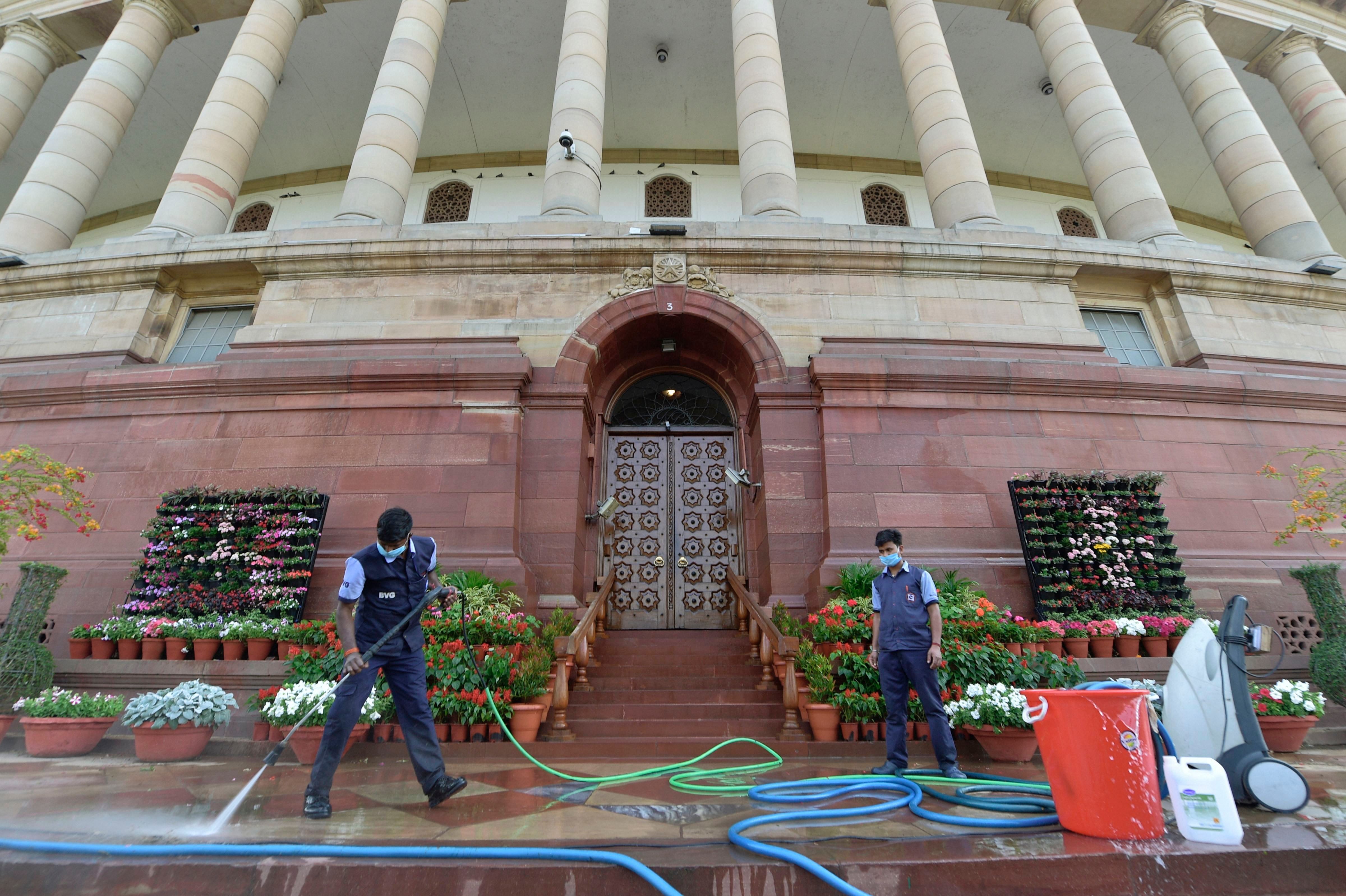 Workers sanitize the Parliament house as a precautionary measure against coronavirus, in New Delhi, Saturday, March 21, 2020. Credit: PTI Photo