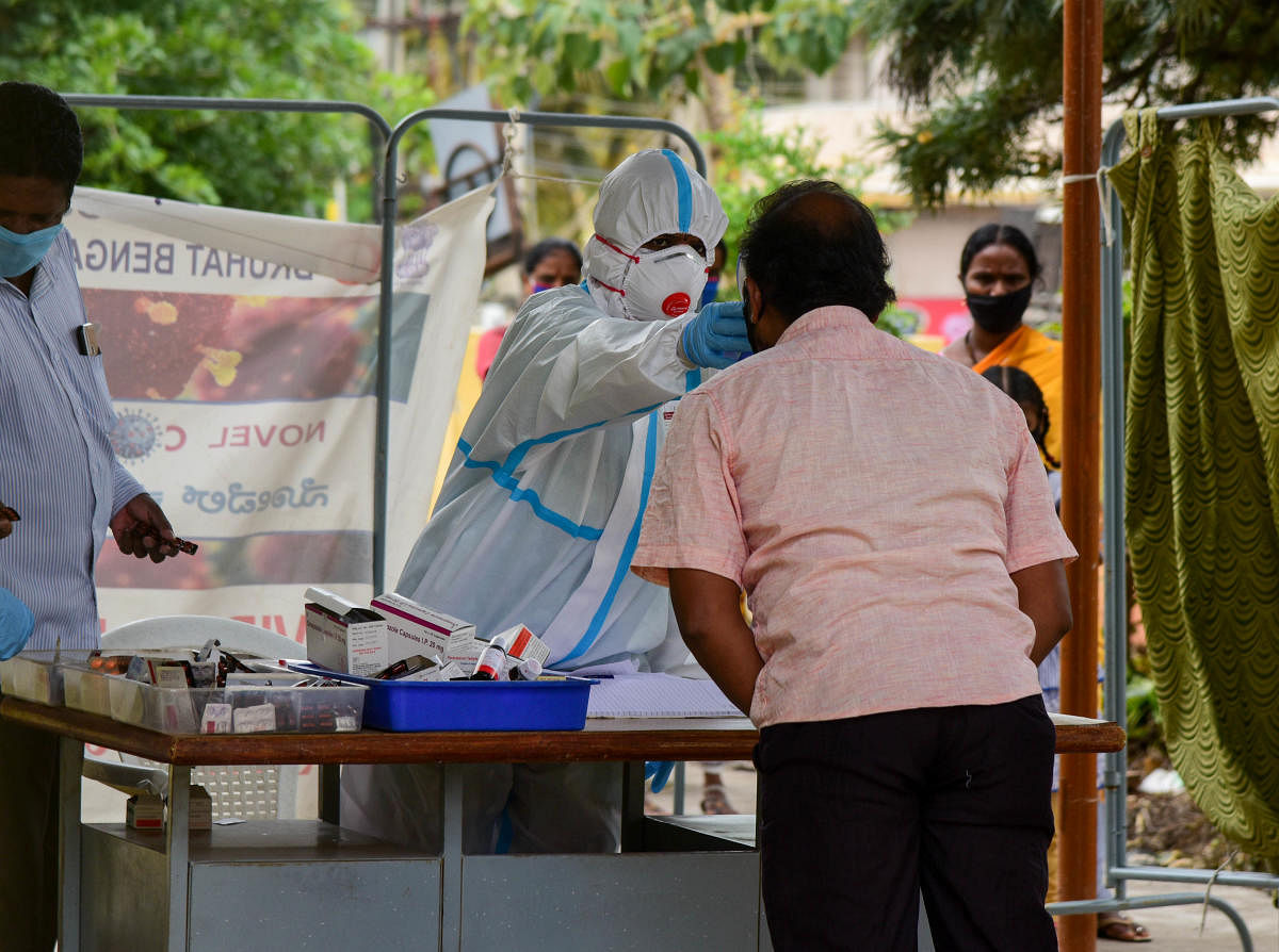 A healthcare worker tests people for Coronavirus in T Dasarahali on Tuesday. DH Photo/B H Shivakumar