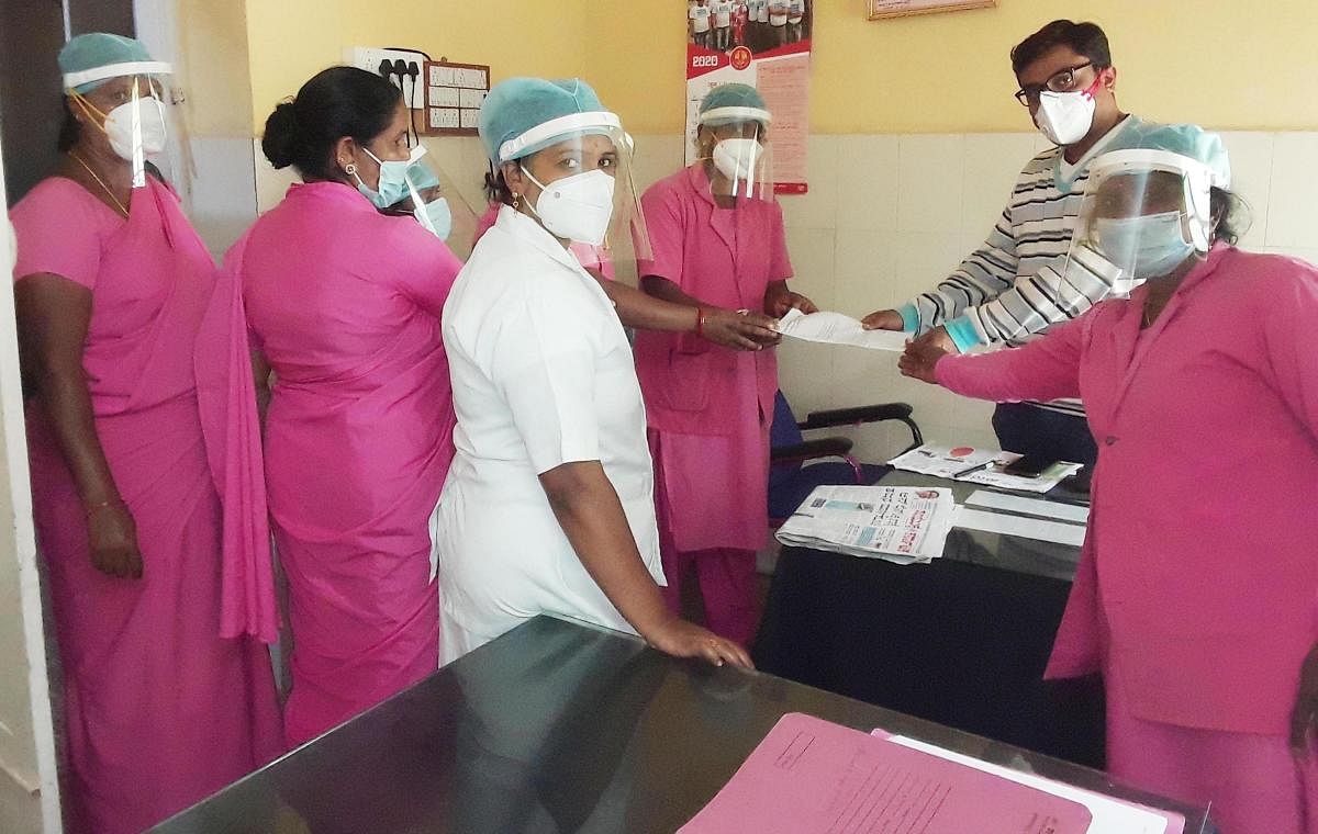 Asha workers submit a memorandum to Dr Anil, administrator of Community Health Centre in Halebid, Hassan district, on Wednesday.