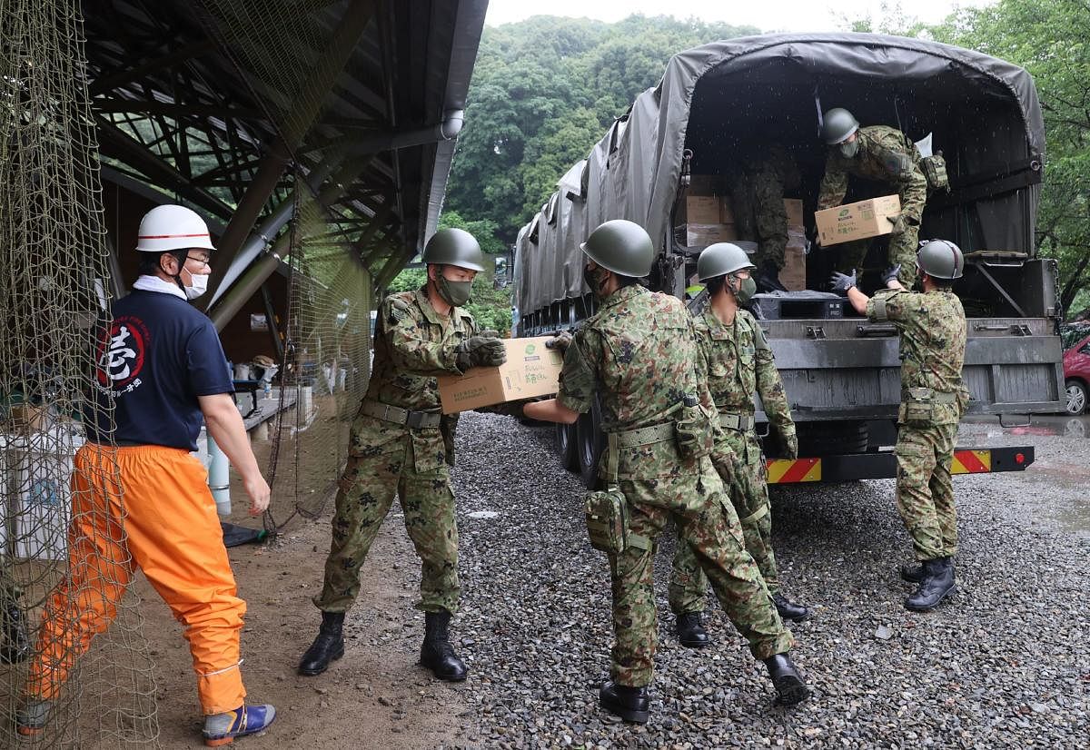 Members of Japan Self-Defense Forces unload relief supplies in the flood hit village of Kumamura, Kumamoto. Credit: AFP Photo