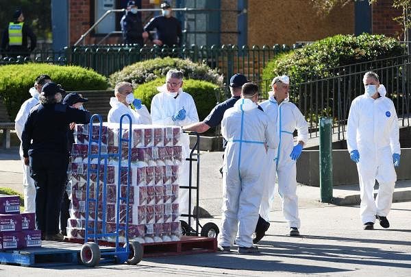 Personnel prepare to distribute goods inside a public housing tower locked down in response to an outbreak of Covid-19 in Melbourne. Credit: Reuters