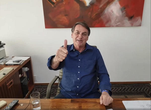 A grab from a video shared on July 8, 2020 on the official Facebook page of Jair Bolsonaro shows Brazilian President Jair Bolsonaro gesturing while having his hydroxychloroquine dose, after having tested positive for Covid-19. Credit: AFP Photo