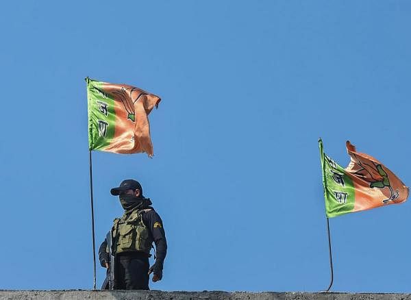 A secuity person guards on the top of the residence of BJP leader Sheikh Waseem Bari in Bandipora district of north Kashmir. Credit: PTI Photo