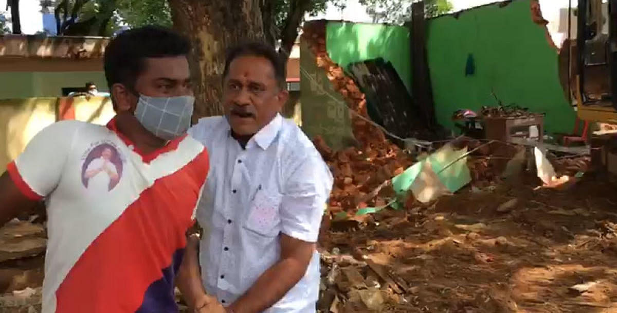 Former MLA Ramesh Babu Bandisiddegowda catches hold of the operator of the excavator, at Arakere village in Srirangapatna taluk, Mandya district on Thursday. DH PHOTO