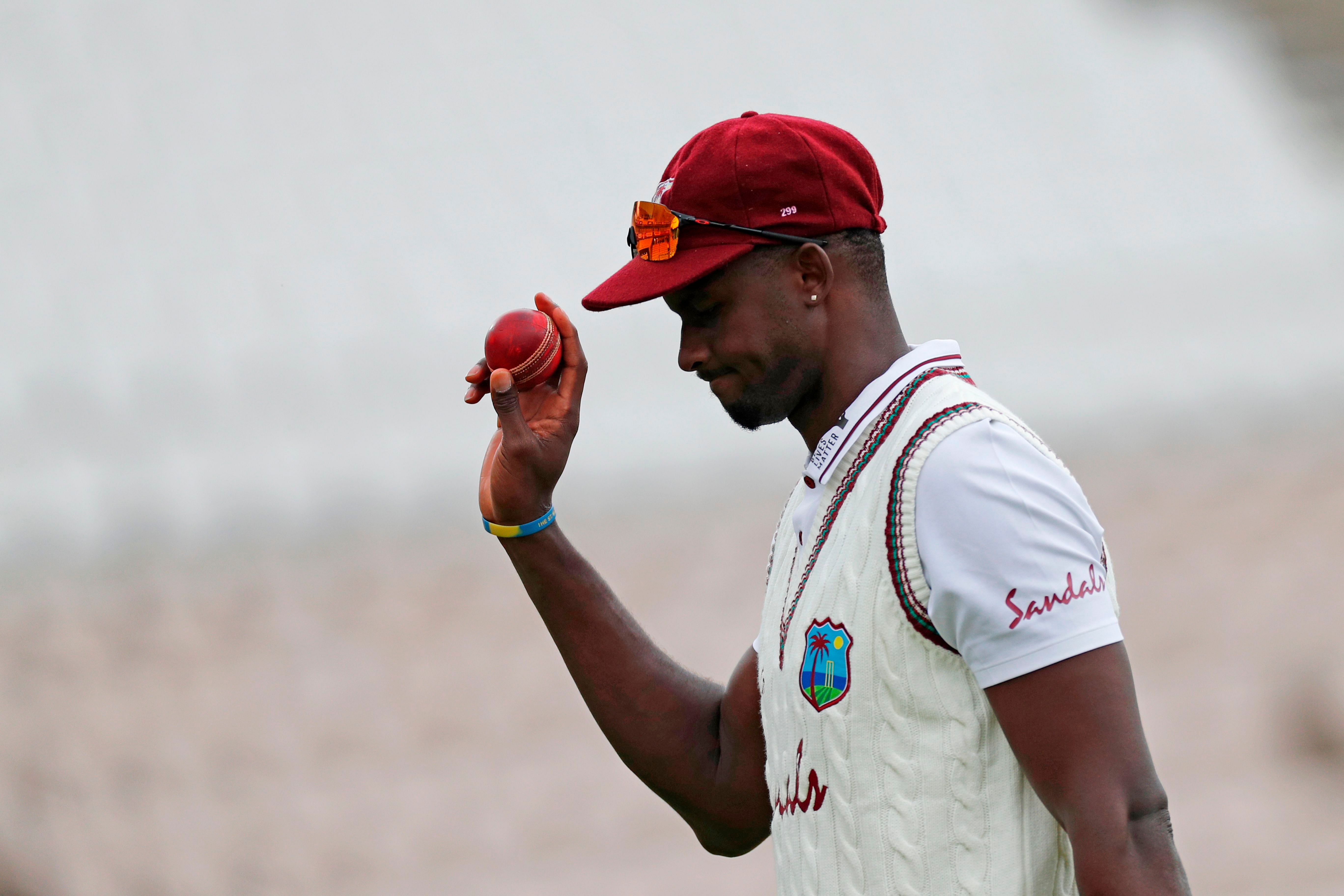 West Indies' Jason Holder leaves the field with the ball after taking six wickets to help bowl out England for 204 runs. Credit: AFP