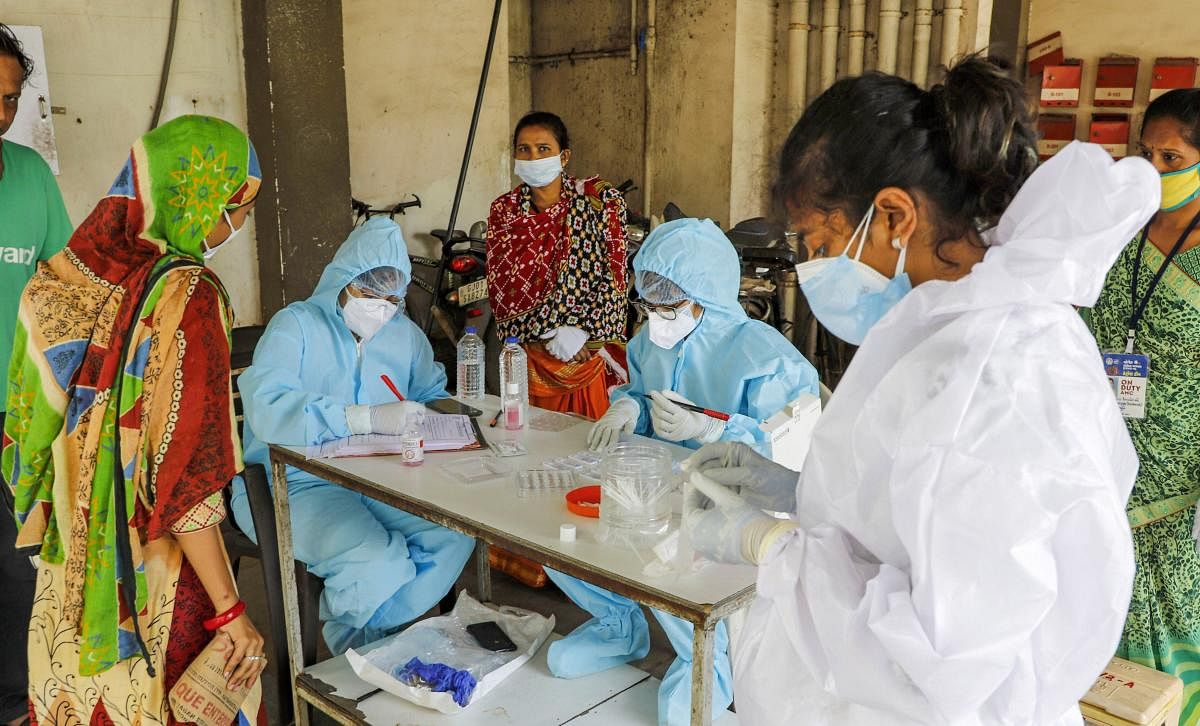 Health workers prepare for conducting rapid antigen testing for diagnosis of Covid-19 cases, at a locality in Ahmedabad. Credit: PTI Photo