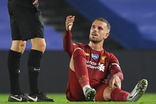 Liverpool's English midfielder Jordan Henderson (R) goes down after tacking knock during the English Premier League football match between Brighton and Hove Albion and Liverpool at the American Express Community Stadium in Brighton, southern England on July 8, 2020. Credit: AFP Photo