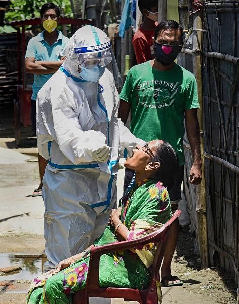 Health workers collect swab samples from the residents for COVID-19 tests during a door-to-door campaign, in Pandu area of Guwahati. Credit: PTI Photo
