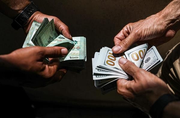 People exchange Lebanese pound and US dollar notes on the black market in Lebanon's capital Beirut. Credit: AFP Photo