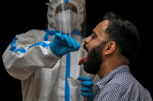 A health worker in personal protective equipment (PPE) collects a sample using a swab from a person to conduct tests for the coronavirus disease. Credit: Reuters